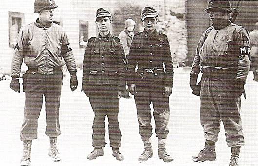 Američtí vojáci se dvěma mladými zajatci SS nedaleko Bastogne za bitvy o Ardeny