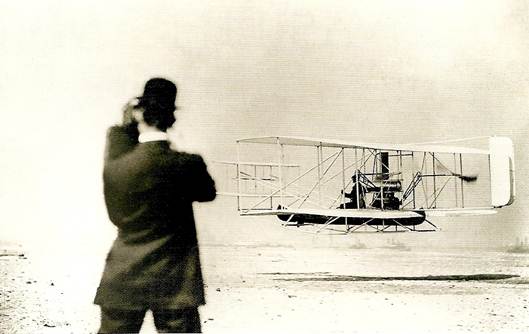 Wilbur Wright fotografuje svého bratra Orvilla při zkušebním letu ve Fort Myers roku 1909