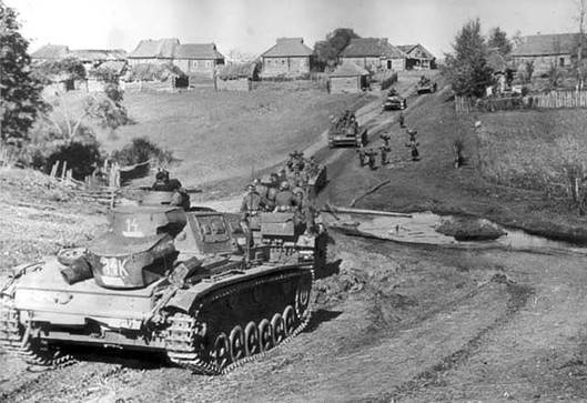 Německé tanky Pz Kpfw III. postupují ruskou vesnicí